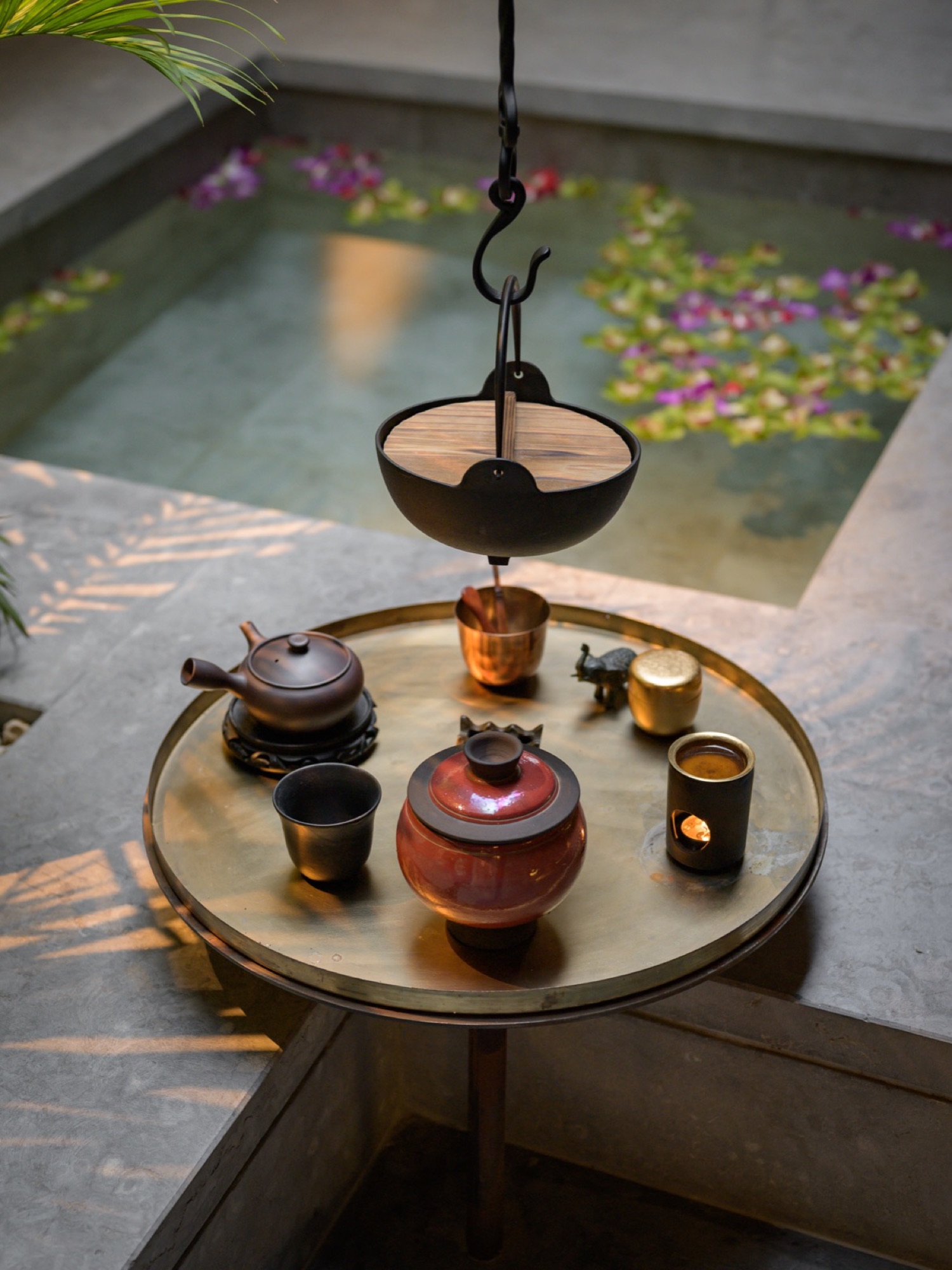 A brass tray set with vessels above a still pool