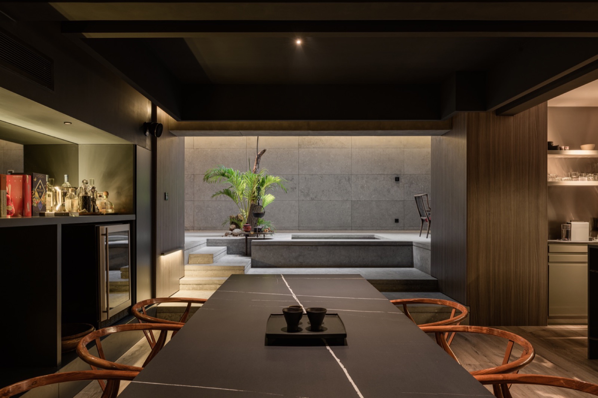 A long dining room in stone and dark wood
