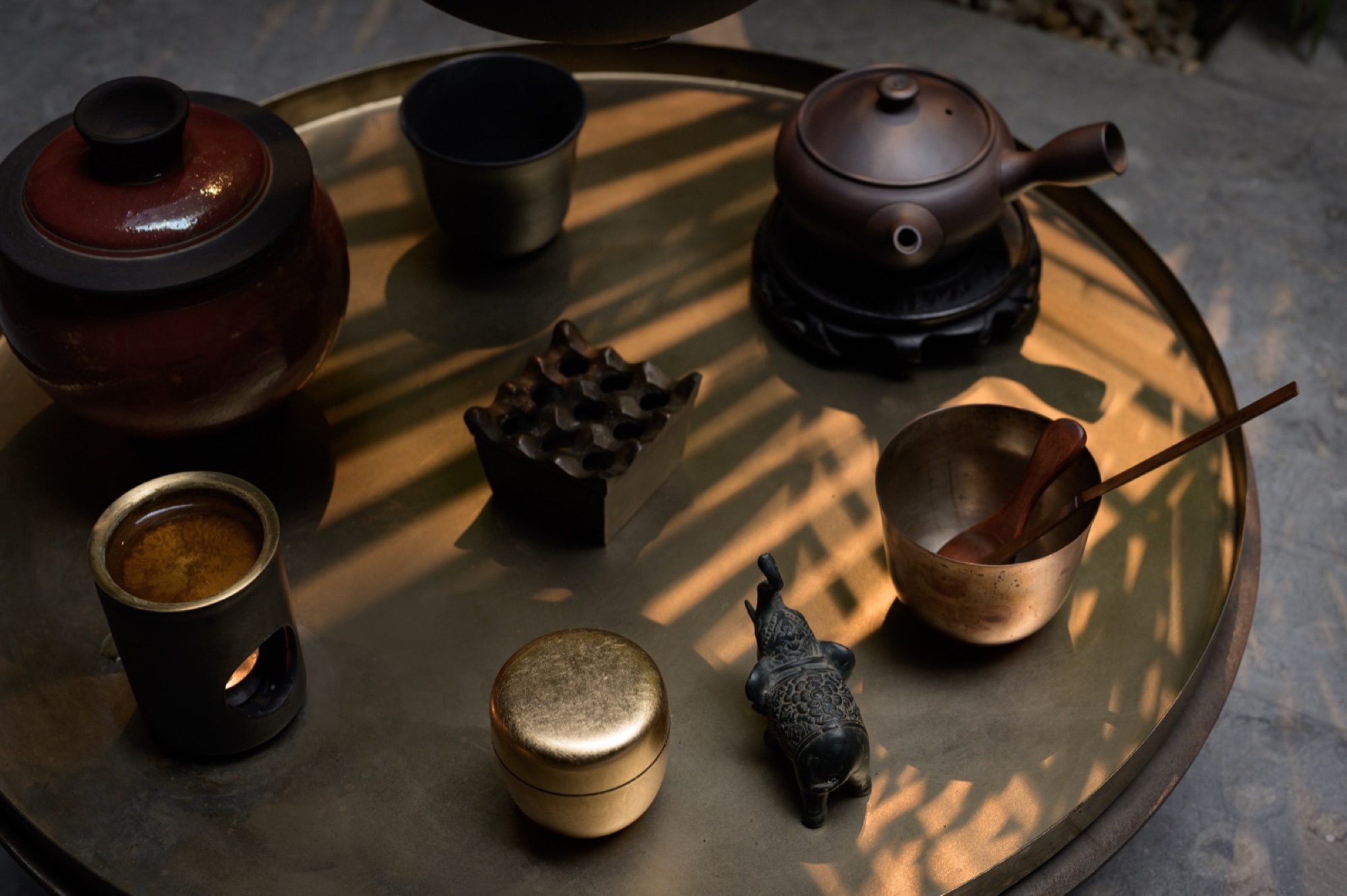 Vessels and boxes arranged on a round bronze tray