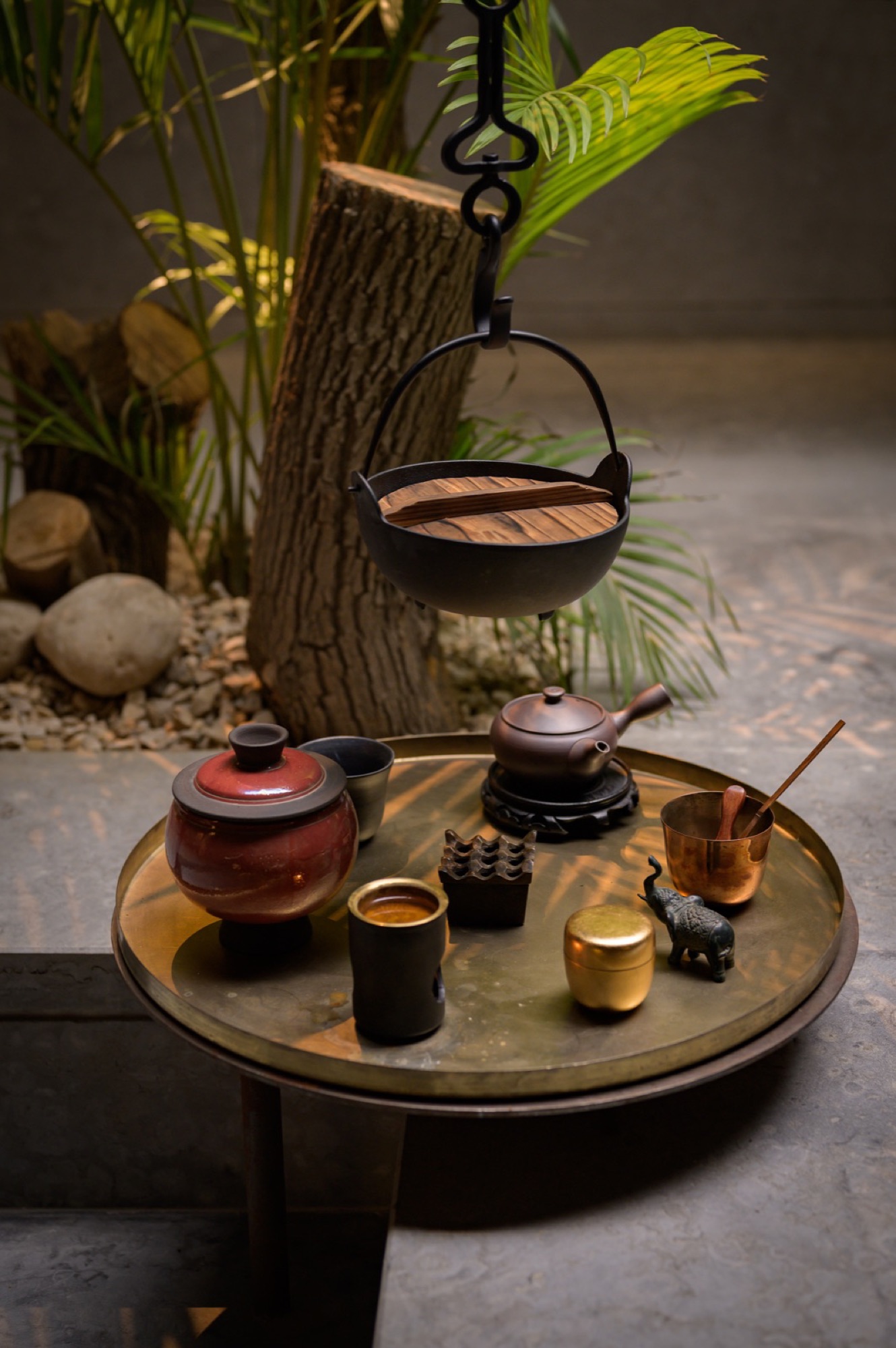 A hanging vessel over water strewn with petals