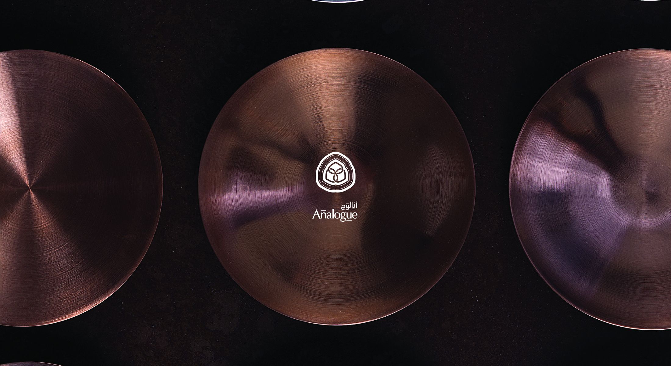 Copper and mirror-polished discs side by side, the Analogue seal struck at the centre of one